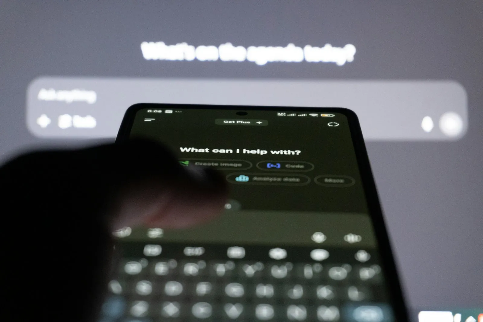 Persona que escriu en un mòbil amb un xatbot d'IA a la pantalla